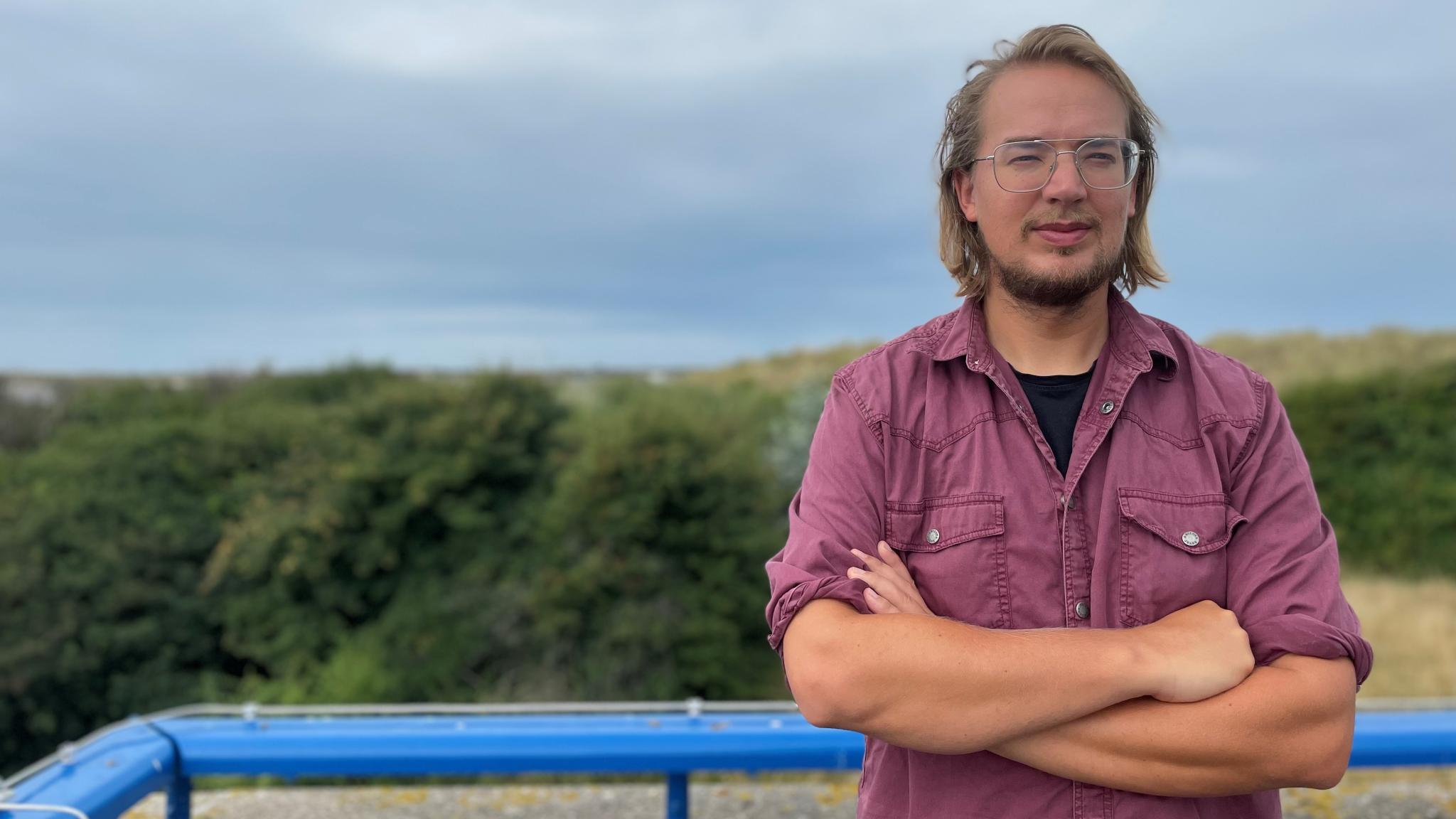 Persoon trots staat met handen over elkaar voor het wad