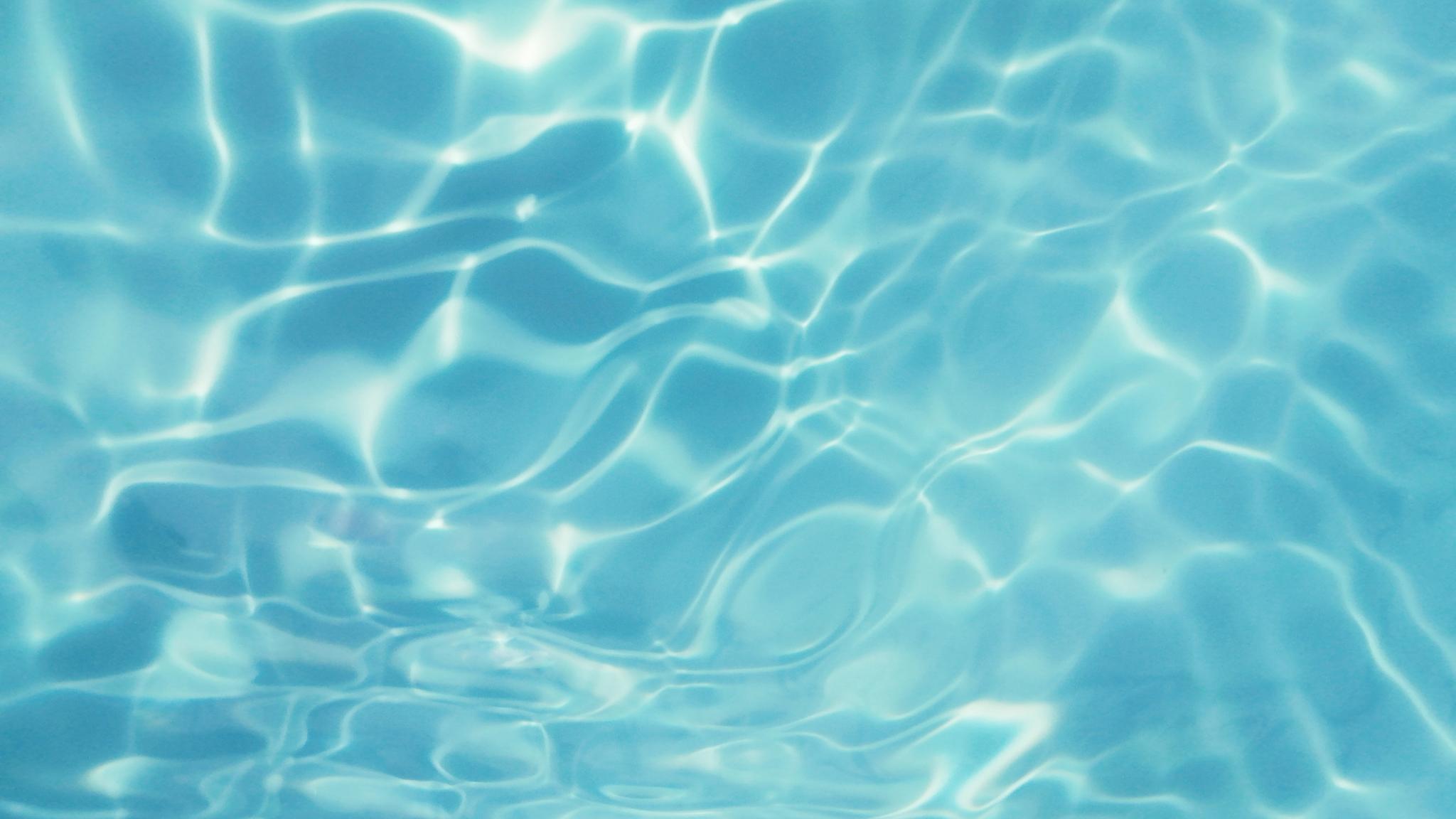 Light blue water surface with reflection of the sun