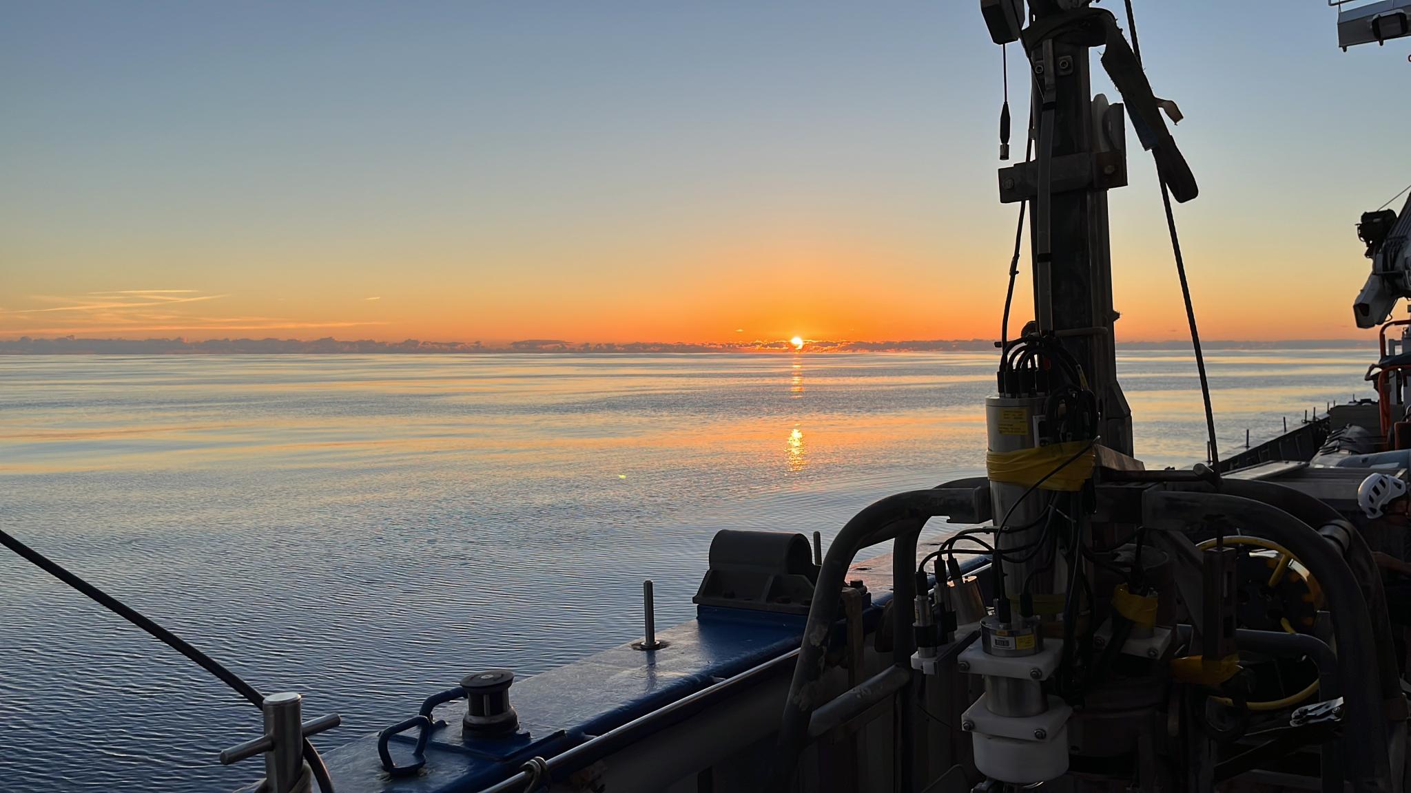 Sun setting in the water seen from the ship (RV Pelagia)