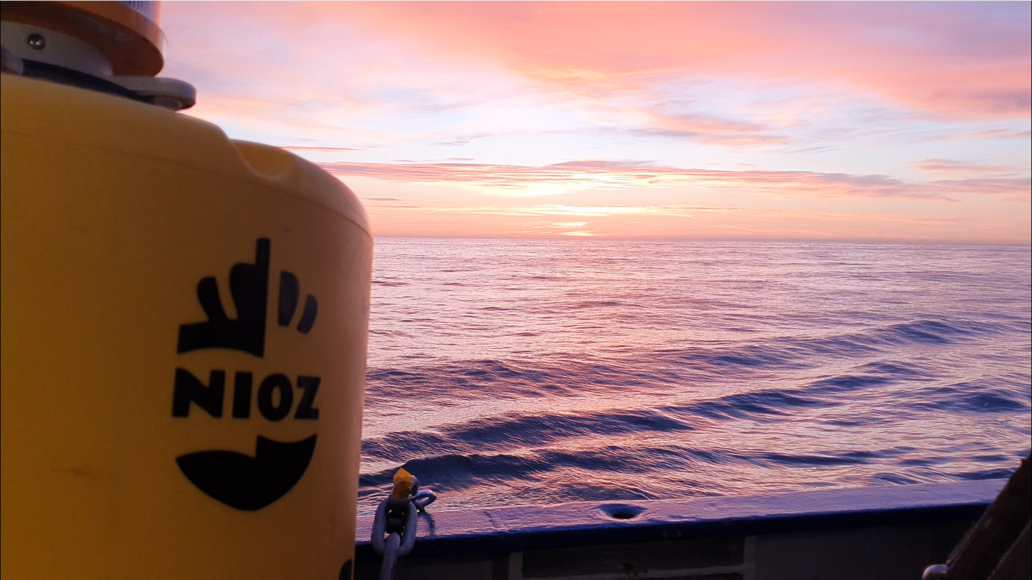 A view from aboard the ship, looking out over the ocean towards the sunset.