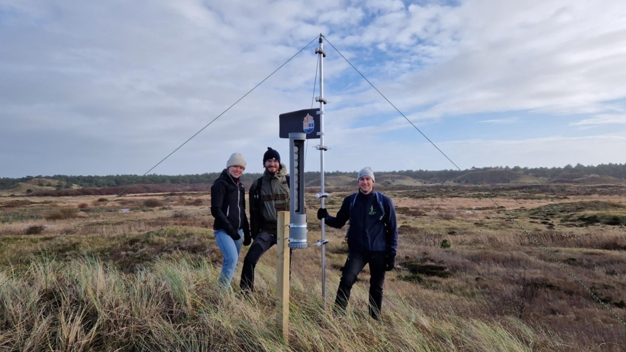 Drie mensen en het gereedschap dat zand vangt