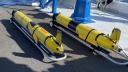 Drie gele torpedo achtige onderzoeksapparaten wachten op tewaterlating aan boord van het onderzoeksschip Pelagia.