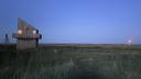 A wooden house and the beacon on the island Griend at dusk
