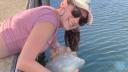 Hannah hanging over the water with a barrel jellyfish, Rhizostoma pulmo. (photo: Quinten van Hove)