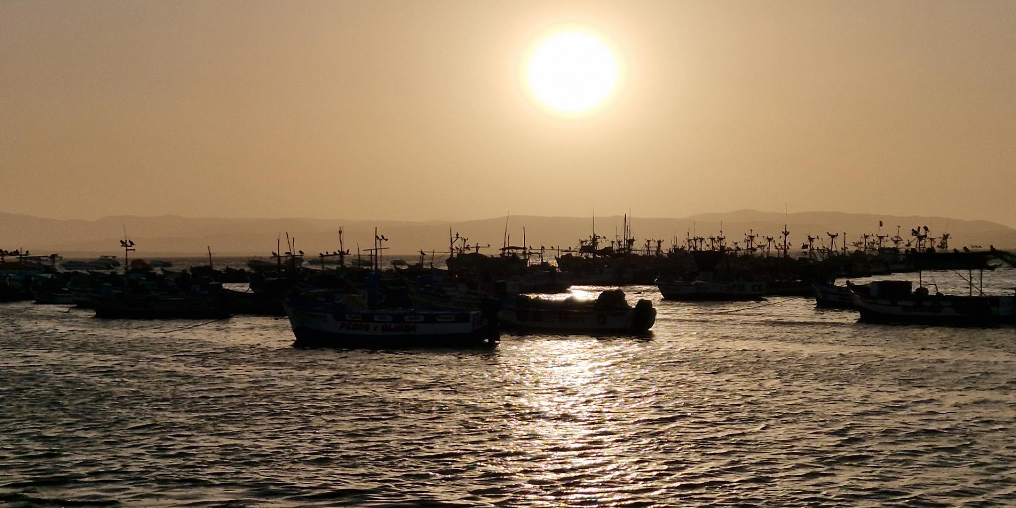 Zonsondergang en zee, oranje lucht door stof