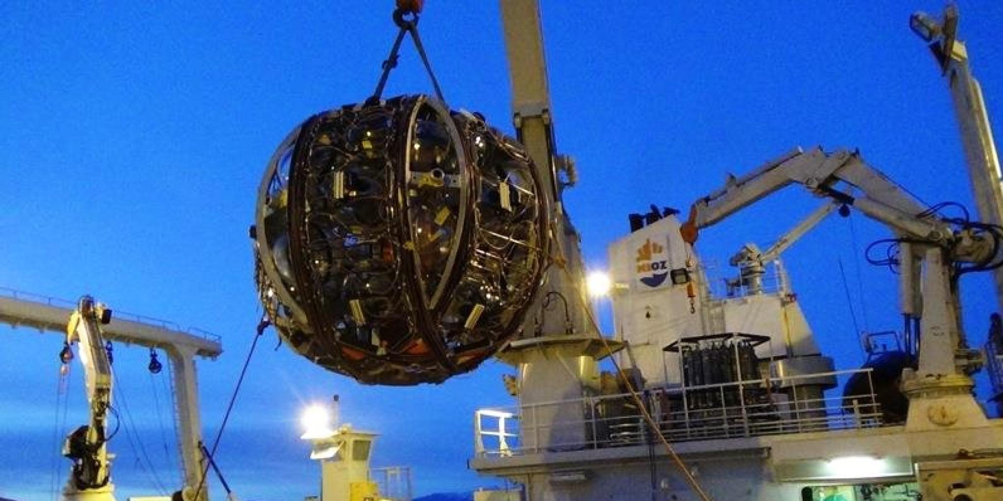 De launcher die NIOZ ontwikkelde voor KM3NeT: de grote 'bal' bevat een detectielijn met de eigenlijke glazen bollen met detectoren bevestigd. Bij het raken van de zeebodem stijgt de launcher op naar het oppervlak en ontrolt de detectielijn als een draadspoel. (foto: NIOZ)