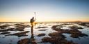 A person does measurements in the undeep waters of an estuary