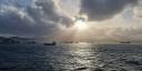 The sun pierces through the clouds and through the dust that is blowing through the air of Mindelo harbour.