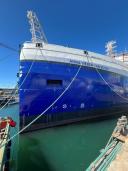 Een blauw schip aan touwen in een zonnige omgeving