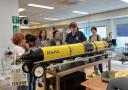 Edwin Keijzer, instrument maker at the National Marine Facilities, explains to some students how the glider works (Photo credit: Paulien Koster).
