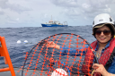 Darshika Manral is ready to release the Sargassum drifter: the MetOcean Stokes drifter (white disc in the foreground) encapsulated in a net designed to attach itself to floating Sargassum and drift with it. (Photo: Erik Zettler)